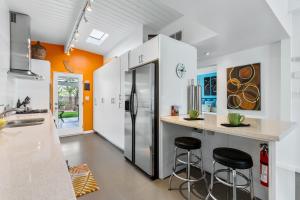 a kitchen with a refrigerator and two bar stools at R & R Rendezvous in Palm Springs