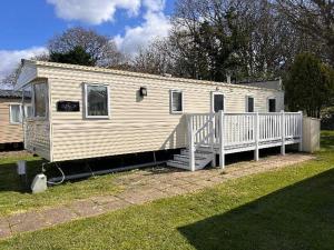 een stacaravan met een veranda en een wit hek bij Sussex by the sea holiday home in Hastings