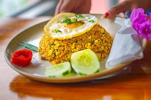 a plate of food with an egg on top at Hub Tata Guesthouse in Tuktuk Siadong