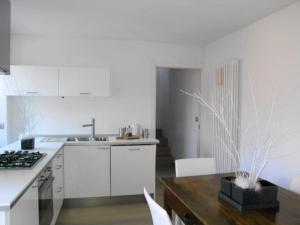 cocina con armarios blancos y mesa de madera en Valle D'Aosta a 360° - Ideal for smart working, en Aymavilles