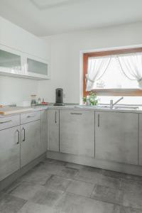 a white kitchen with a sink and a window at Ferienwohnung Speidel Rottenburg am Neckar in Rottenburg +10 photos