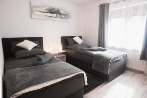 a bedroom with two beds and a window at Ferienwohnung Speidel Rottenburg am Neckar in Rottenburg