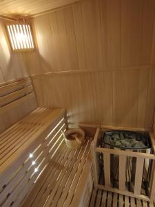 an inside of a wooden sauna with a basket of rocks at jolie maison neuve - malisone - in Pont-Sainte-Maxence