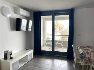 uma sala de estar com uma porta de vidro deslizante para um pátio em Casa Vacanza Acquamarina em Porto Torres