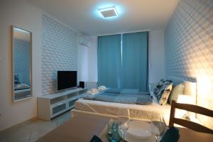 1 dormitorio con 1 cama azul y TV en Airport Luxury Apartment with Balcony + Free parking en Vecsés