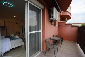balcón con mesa, sillas y cama en Airport Luxury Apartment with Balcony + Free parking en Vecsés