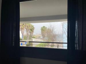 a window with a view of a palm tree at Casa Vacanza Acquamarina in Porto Torres