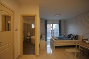 1 dormitorio con 1 cama y baño con bañera en Airport Luxury Apartment with Balcony + Free parking en Vecsés
