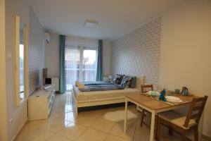Un dormitorio con una cama y una mesa. en Airport Luxury Apartment with Balcony + Free parking en Vecsés