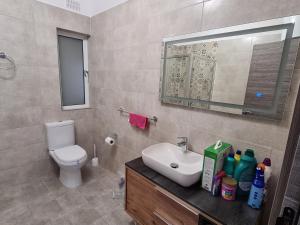 a bathroom with a sink and a toilet and a mirror at Cescaren Gozo Ghajnsielem in Għajnsielem