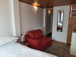 a bedroom with a red chair next to a bed at Mildenhall Suffolk in Mildenhall