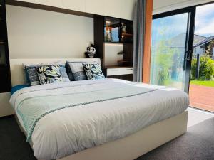 um quarto com uma cama grande e uma janela grande em Modern Comfy 3 Bedrooms House in Chartwell em Hamilton