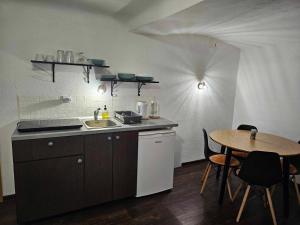 eine Küche mit einem Waschbecken und einem Tisch mit Stühlen in der Unterkunft Apartment Room Old City - Apartment Slavija in Škofja Loka