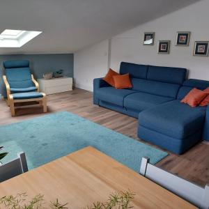 een woonkamer met een blauwe bank en een stoel bij St Loup in Bessan