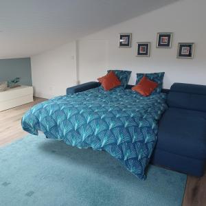 een bed met een blauw dekbed en een blauwe bank bij St Loup in Bessan