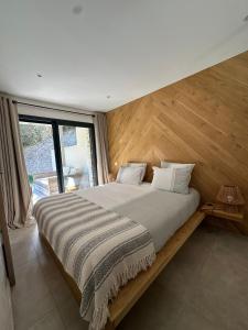 a bedroom with a large bed with a wooden wall at La Palmeraie in Bonifacio