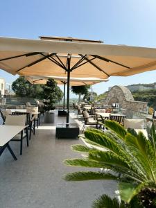 a patio with tables and chairs under an umbrella at The Rest Port Argento in Bodrum City