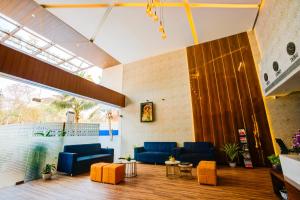 a lobby with blue couches and orange chairs at KAMAT'S DAFFODIL RESORT GOA in Pilerne