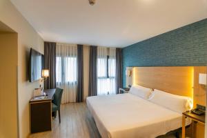 una camera d'albergo con letto e scrivania di Hotel Zentral Ramiro I Oviedo a Oviedo