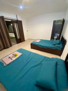 a bedroom with two beds and a blue sheet at شاليه للايجار اليومي بالريف الاوروبي in Qaryat ash Shamālī