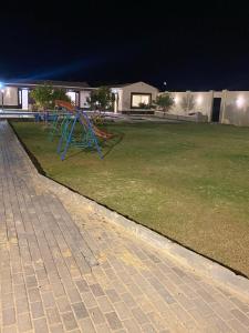 un parque nocturno con un parque infantil azul en شاليه للايجار اليومي بالريف الاوروبي, en Qaryat ash Shamālī
