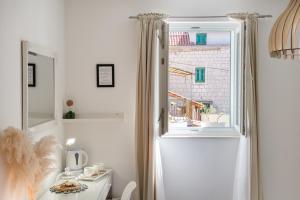 Central Split rooms and apartments Paese في سبليت: غرفة بيضاء مع نافذة وطاولة ومغسلة