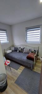 um quarto com uma cama grande e 2 janelas em Apartman Heli Meli 1 em Jajce