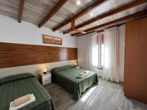 Una habitación de hotel con dos camas y una ventana. en VILLA MasÍa CAL TONI, en Pineda de Mar