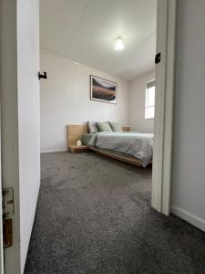 a bedroom with a bed in a white room at Private Room in Kawakawa
