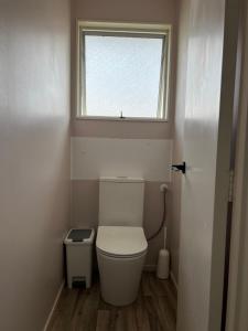 a small bathroom with a toilet and a window at Private Room in Kawakawa