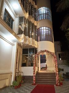 a large building with an entrance with a red carpet at Hotel Samrat Heavens Meerut in Meerut