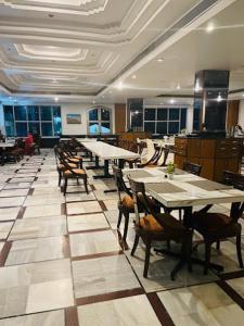 a restaurant with tables and chairs in a room at Hotel Samrat Heavens Meerut in Meerut