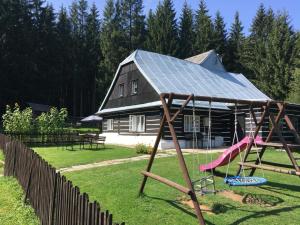 a house with a solar roof and a swing at Roubenka Kuklík in Sněžné