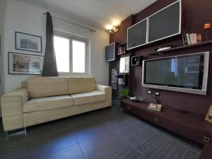 a living room with a couch and a flat screen tv at casamares in Isola delle Femmine