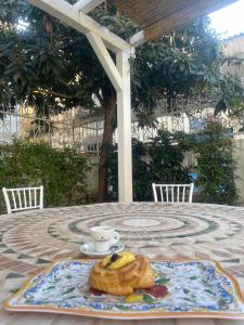 una mesa con un plato de comida y una taza de café en Il Borgo civ.15, en Paola