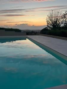 una piscina de agua con una puesta de sol en el fondo en Castello di Calliano, en Calliano