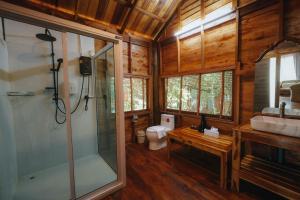 a bathroom with a shower and a sink and a toilet at บ้านสวนแก้วคำแพง Baan Suan Kaew Khampaeng in Udon Thani