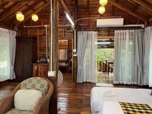 a bedroom with a bed and chairs in a room at บ้านสวนแก้วคำแพง Baan Suan Kaew Khampaeng in Udon Thani