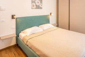 - une chambre avec un grand lit et une tête de lit verte dans l'établissement Panoramic Apartment Rudi, à Garde