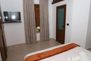 a bedroom with a bed and a tv on the wall at Villa Palma Center in Berat