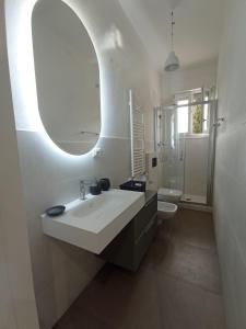 bagno bianco con lavandino e specchio di La Dimora degli Artisti - Bologna a Bologna