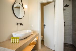 La salle de bains est pourvue d'un lavabo et d'un miroir. dans l'établissement Aethrion Villas & Suites, à Gennadi