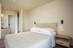 a bedroom with a large white bed and a sink at Aethrion Villas & Suites in Gennadi