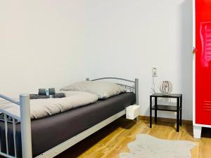 a bed in a room with a white wall at Zur Guten Stube - Self Check In- 