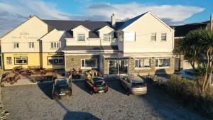 a large house with cars parked in front of it at John Eoinìn's Bar and accommodation in Glencolumbkille