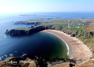 una vista aérea de la playa y del océano en John Eoinìn's Bar and accommodation, en Glencolumbkille