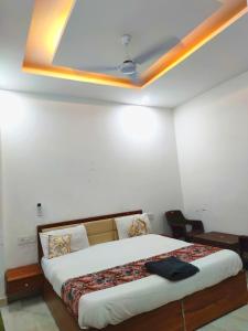 a bedroom with a large bed with a ceiling at Hotel triple s in Karnal