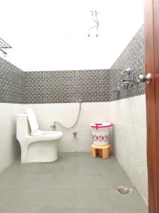 een badkamer met een toilet en een douche bij Airport Forest View Ghugugti Farmstay in Dehradun