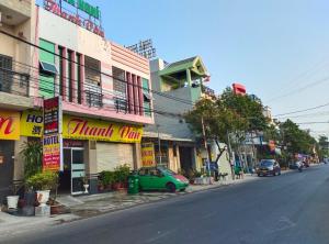 um carro verde estacionado ao lado de uma rua em Hotel Thanh Vân em Thuan An