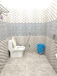 een badkamer met een toilet en een blauwe emmer bij Airport Forest View Ghugugti Farmstay in Dehradun